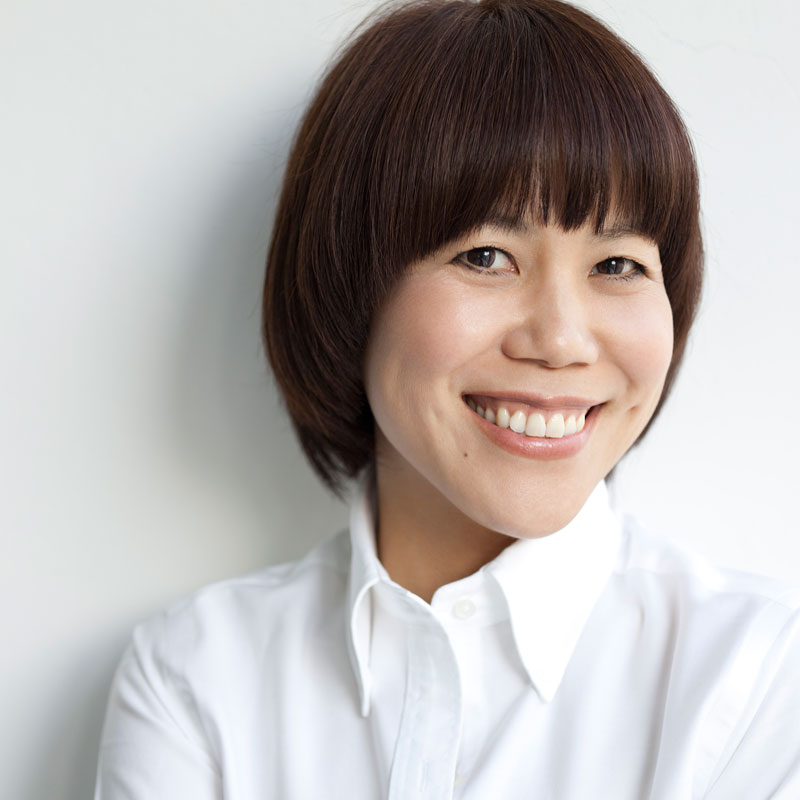 ヘア＆メイクアップアーティストの山本浩未さんが白シャツで微笑んでいる画像