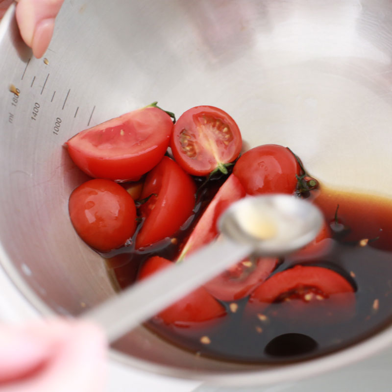 ポン酢、ごま油を加えたボウルの中のミニトマト