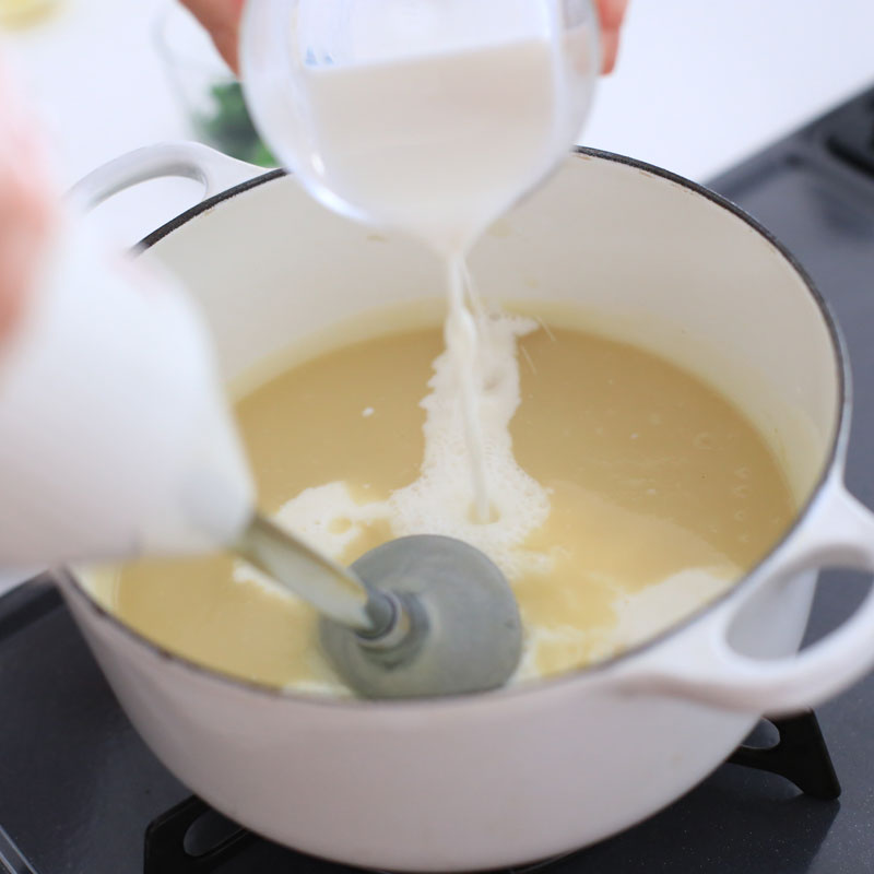 クレソンのポタージュを作っているところ。牛乳を鍋に入れている