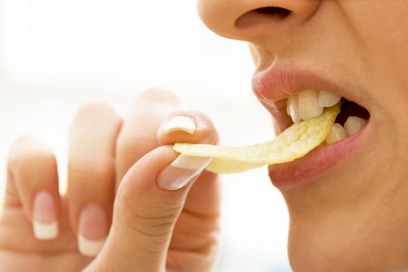 ポテトチップスを食べる女性