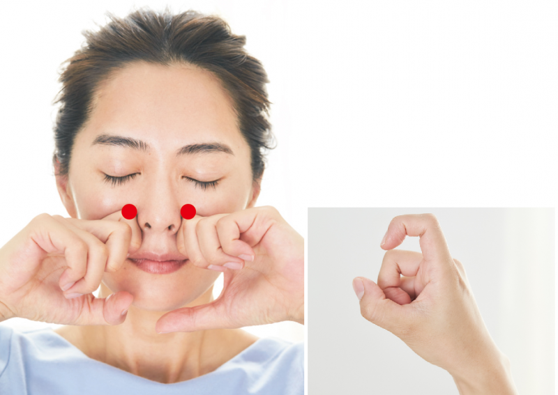 小鼻の横を両手の人差し指の第二関節でプッシュしている女性