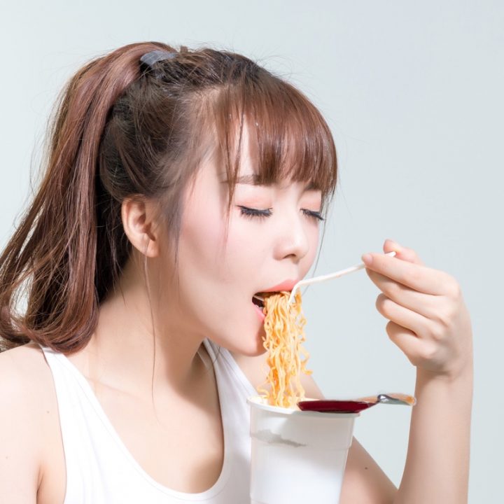 カップ麺を食べる女性