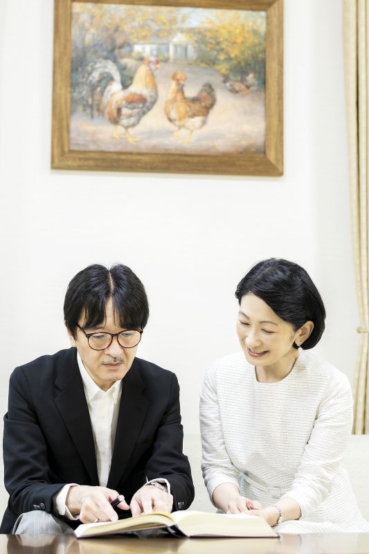 秋篠宮殿下と紀子さまがソファに腰掛け本を見ているところ