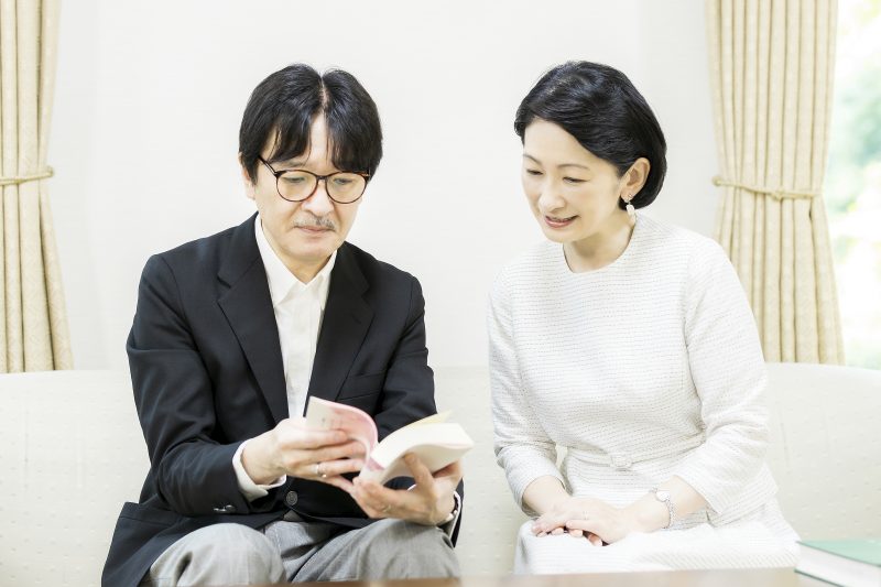 秋篠宮殿下と紀子さまがソファに腰掛け本を見ているところ
