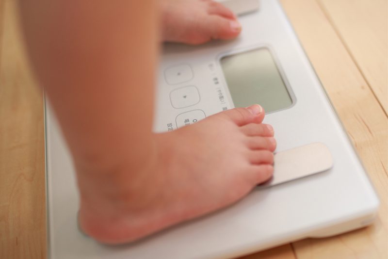体重計と女性の脚