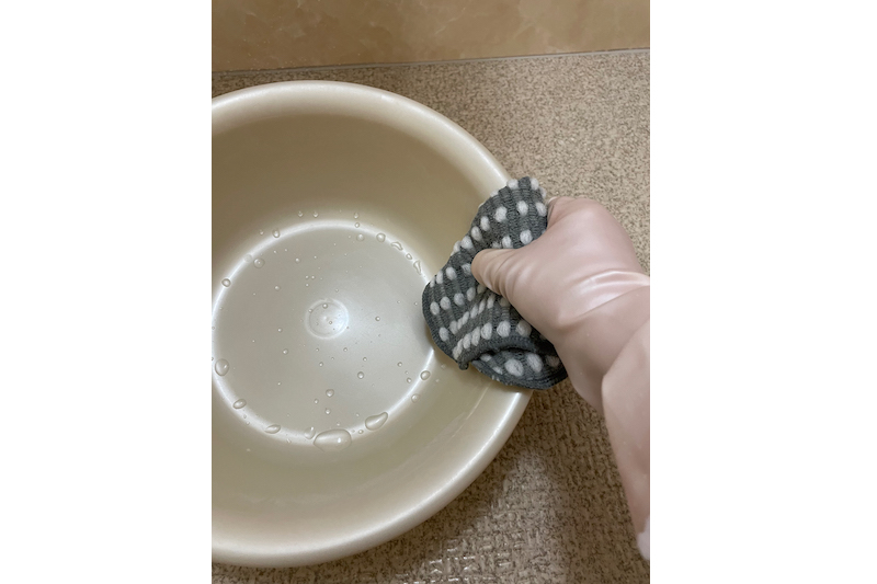 ケユカのsocio 泡立ちクロススポンジ 2枚セットでお風呂の洗面器を掃除している手元