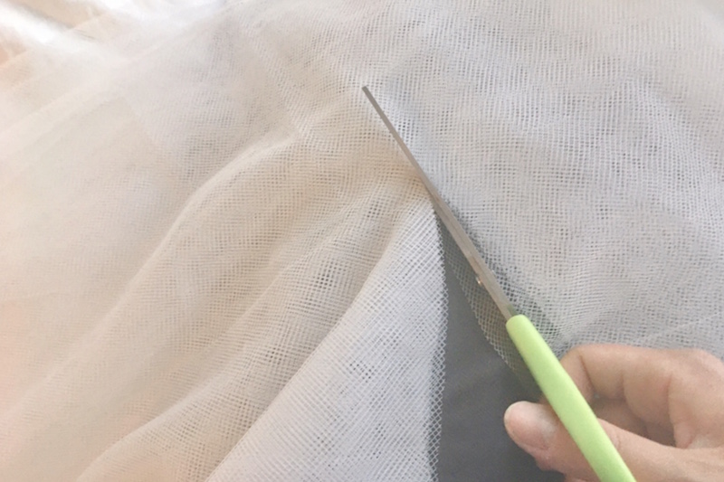 イケアのネットカーテン「リル」をハサミで切っている手元