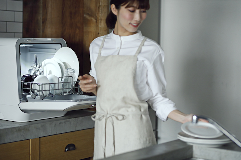狭いキッチンでシロカ『食器洗い乾燥機　UV除菌タイプ』を使用する女性