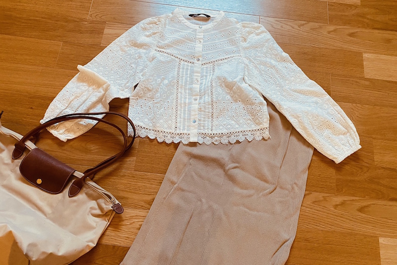 ZARAのカットワーク刺繍入りシャツとベージュのリブタイトスカートとロンシャンのバッグ
