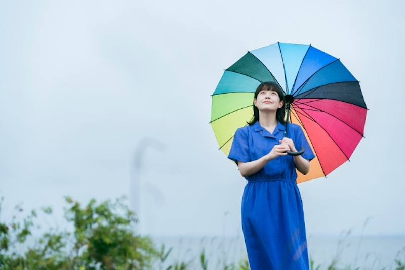 虹色の傘を持つ女性