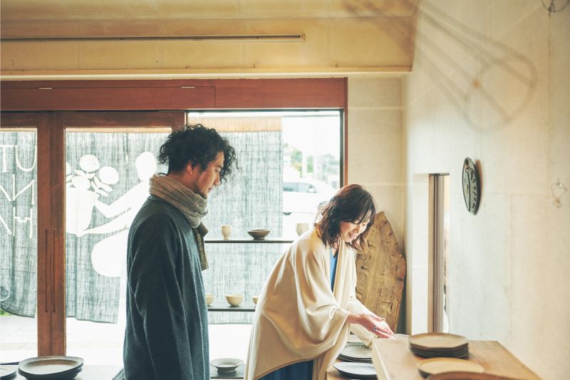 作品展で吉田さんの作品に触れる大塚さん。普段、吉田さんの食器を愛用しているという