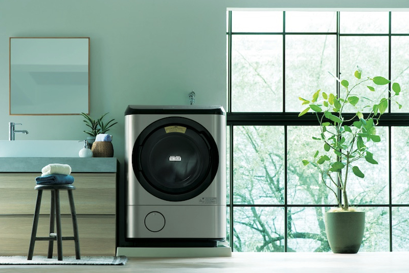 日立グローバルライフソリューションズ『ドラム式洗濯乾燥機　BD-NX120GL』の旧型が洗面台の横にあり、観葉植物がある窓辺