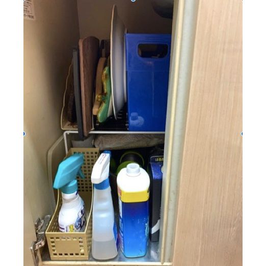 キッチン下の収納スペースにファイルスタンドに収納された洗剤やお皿、まな板などがある