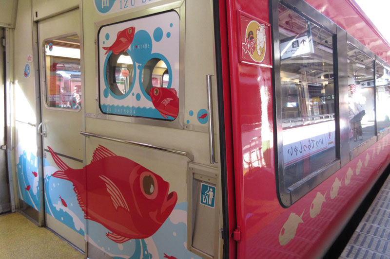 伊豆急のキンメ電車は、内外も赤を基調にしたデザインで、車内はめでたい「キンメダイ」。道中に、こんなサプライズを用意してもいい（乗車券のみで乗車可・時間要確認）