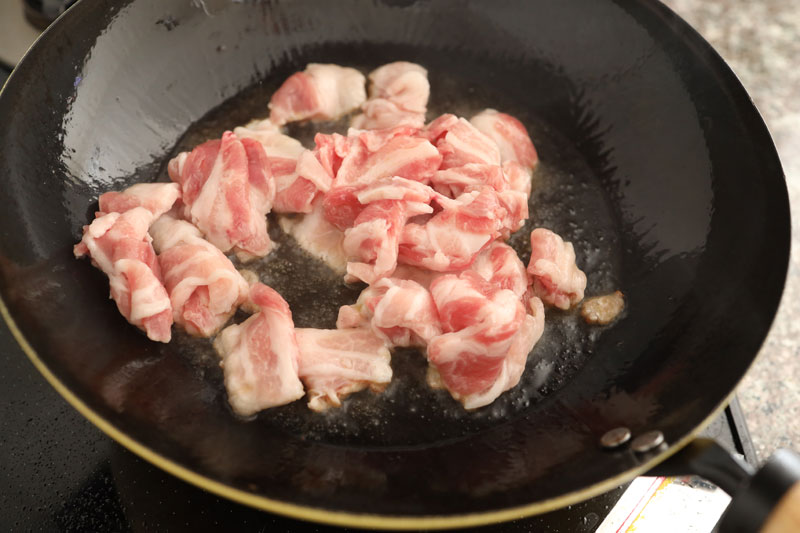 ごま油をフライパンを中火で熱し、豚バラ肉を炒める