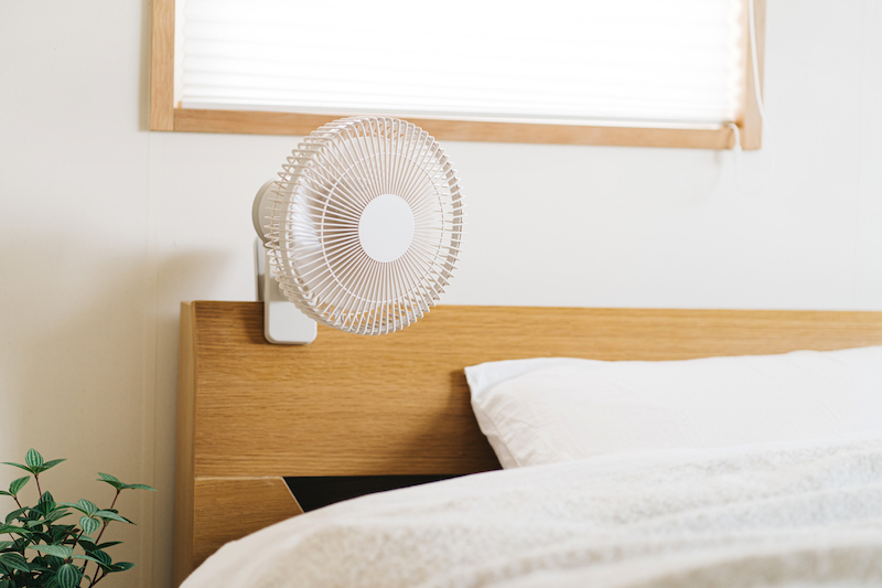 寝室のベッドの頭らへんにシロカ『ポータブルコードレス扇風機 ANDON(アンドン) FAN』が取り付けられている