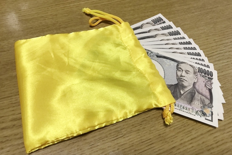 金色の袋に入った一万円札