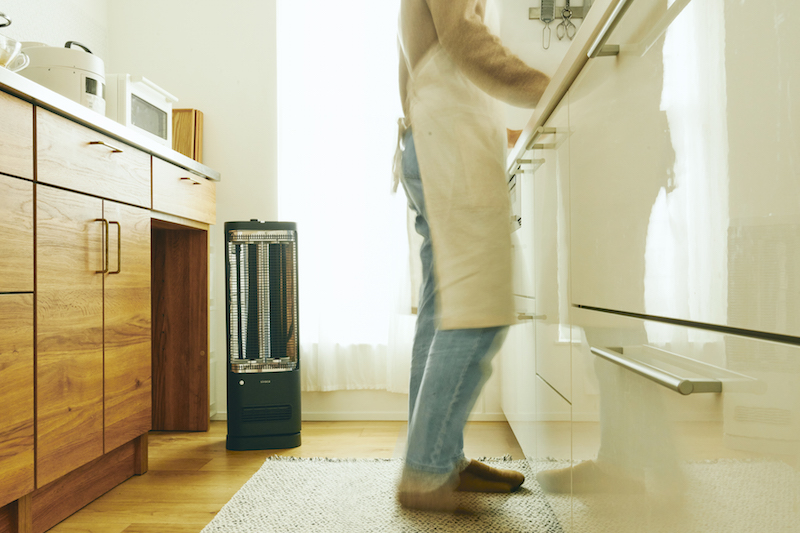 シロカ『足元ファンヒーター付き 遠赤外線暖房機 にこポカ』をキッチンに置き、足元を温めている様子