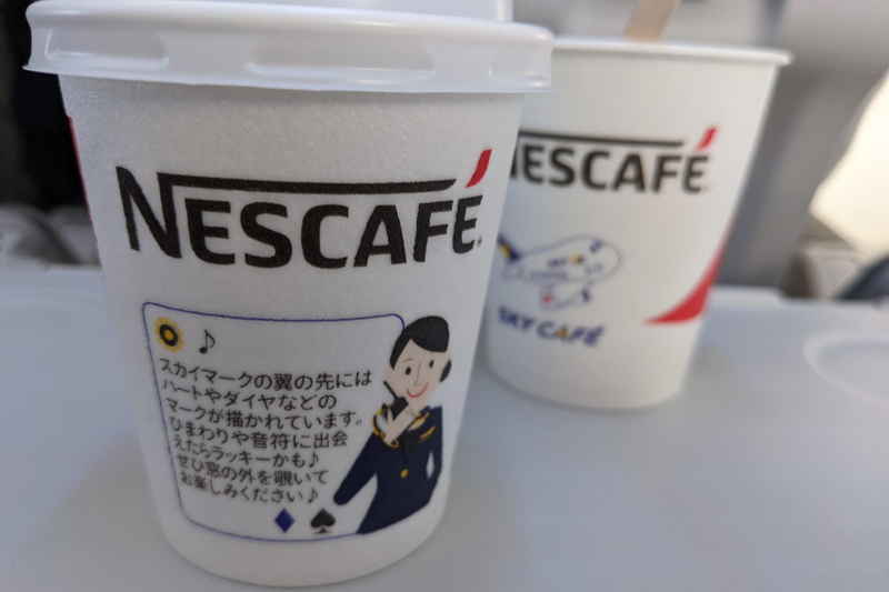 神戸発着便では（全便？）、ストーリーが描かれたカップでネスカフェのコーヒーやキットカットのうれしいサービスも。機内誌もユニークなので、ぜひチェックを（スカイマーク）