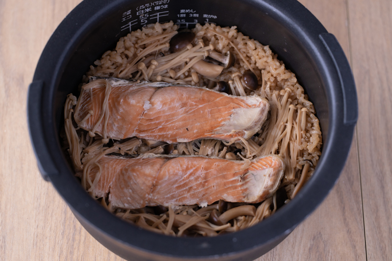 洗米した米と【A】を炊飯釜に入れ、2合の目盛りまで水（分量外）を入れて混ぜる。きのこ、鮭をのせ通常炊飯する。