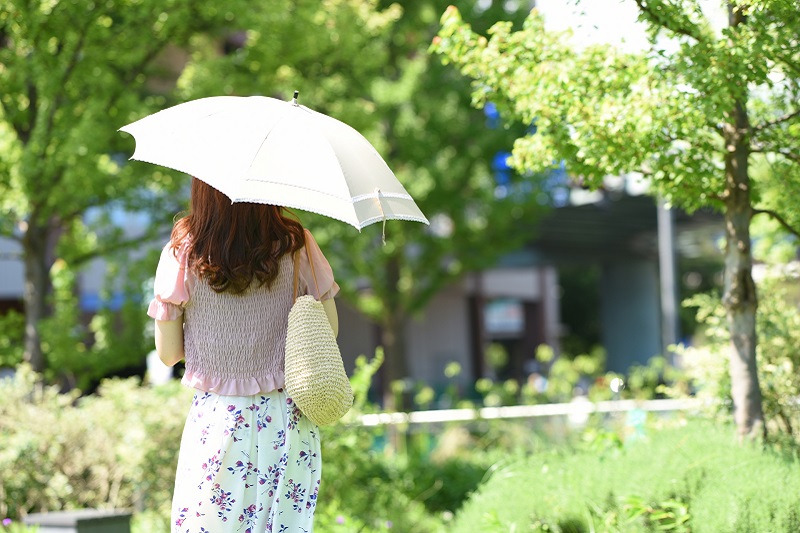 日傘をさした女性が歩いている