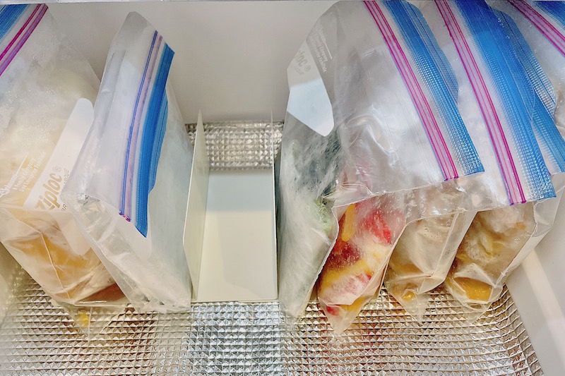 アルミシートが敷かれた冷凍室にジップ付き袋に入れられた冷凍食品が並んでいる