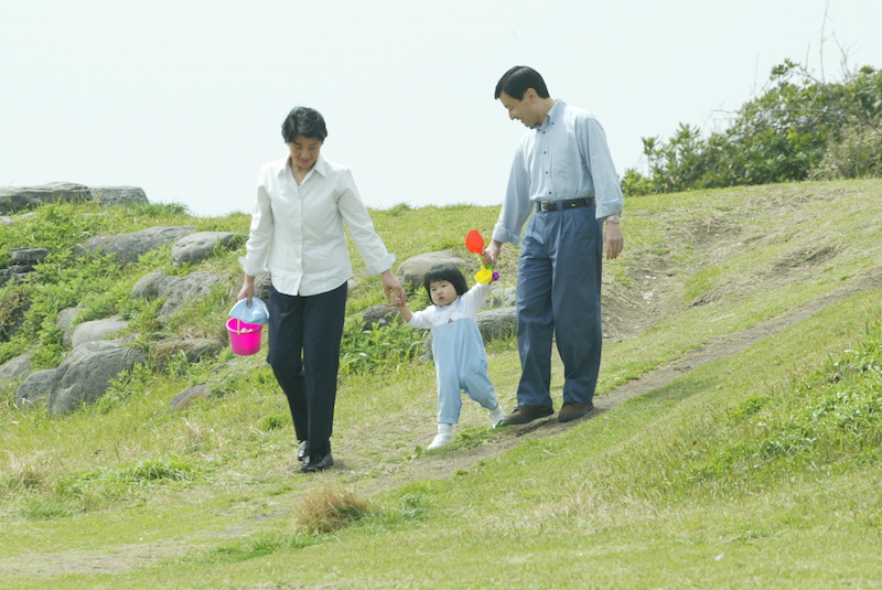2003年4月、葉山御用邸近くの海岸に向かうため、お砂場遊びセットを手に持ち、愛子さまと手をつなぎ歩かれる天皇陛下（当時は皇太子）と雅子さま