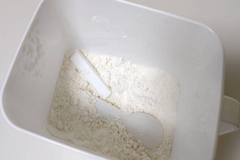 小麦粉を入れた容器に計量スプーンとスティック状の珪藻土が入っている