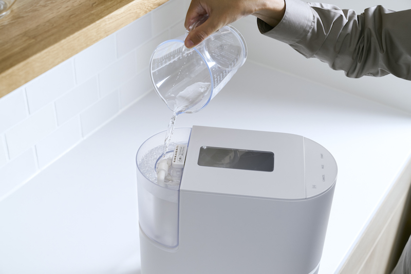 パナソニック『自動計量IH炊飯器 SR-AX1』の給水タンクに水を注ぐ女性の手元