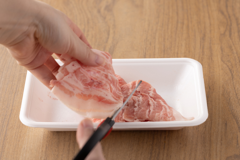 豚バラ肉はキッチンバサミで食べやすい大きさに切る。青ねぎを小口切りにする