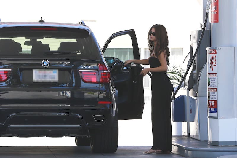 BMWの「X5」にガソリンを入れるセレーナ（2013年9月30日、Ph：AFLO）