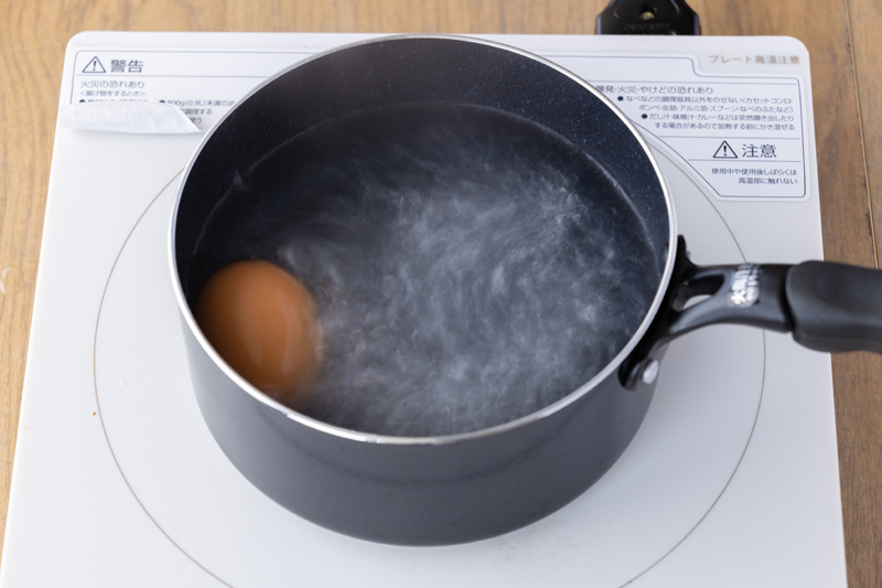 キッチンバサミで食べやすい大きさに切る。その鍋で卵を入れ、7分茹でて取り出し冷やして殻を剥く