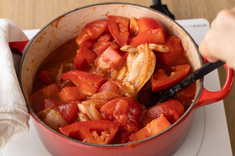 トマト缶とトマトを加え、つぶしながら混ぜて蓋をして弱火で20分煮込む。時々かき混ぜる。※あればローリエも入れる