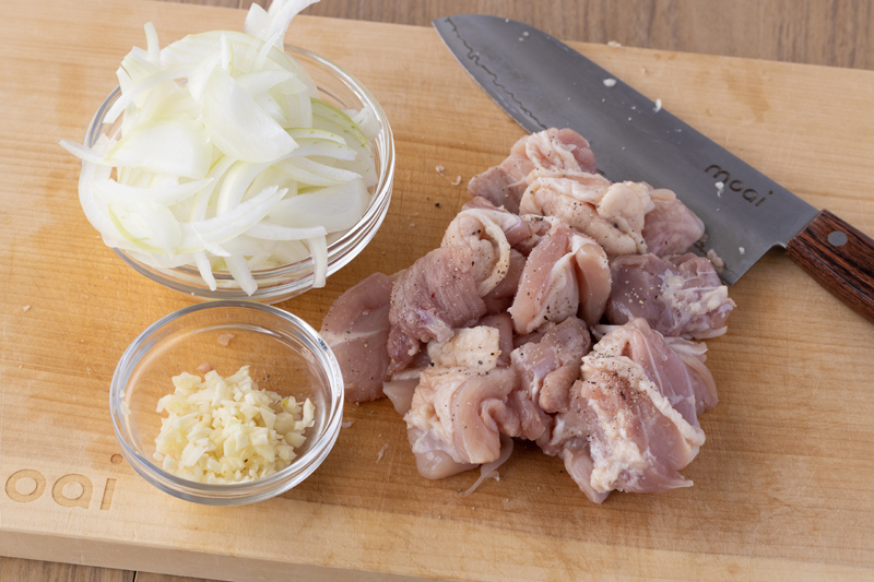 玉ねぎは薄切りに、にんにくはみじん切りにする。鶏もも肉は一口大に切り、塩・こしょうをふる。
