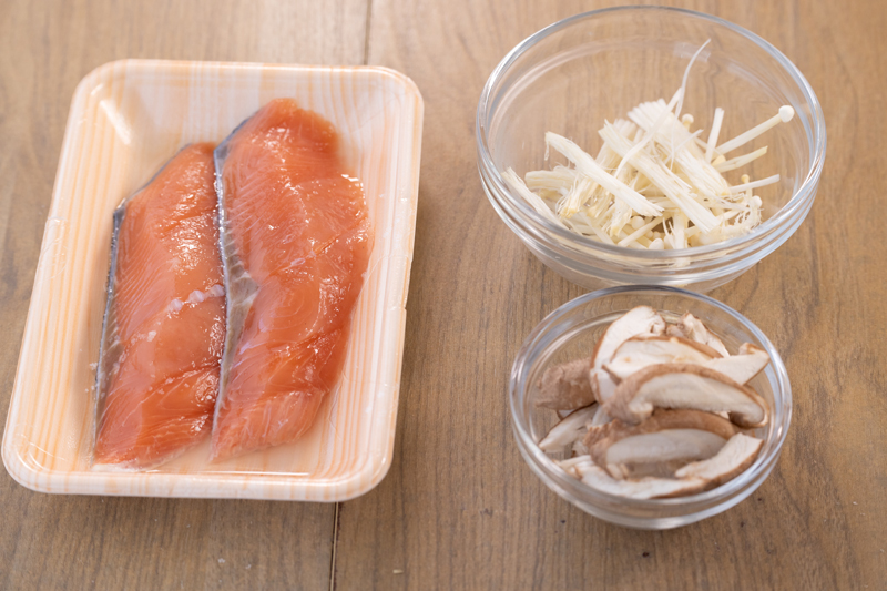 鮭は塩、酒を振って下味をつける。キッチンバサミでしいたけは細切りにする。えのきは石づきを切りとって半分に切る