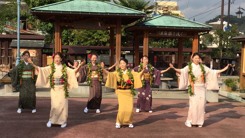 （CP）いわき湯本温泉街にある「鶴の足湯」前で踊る「フラ女将」。