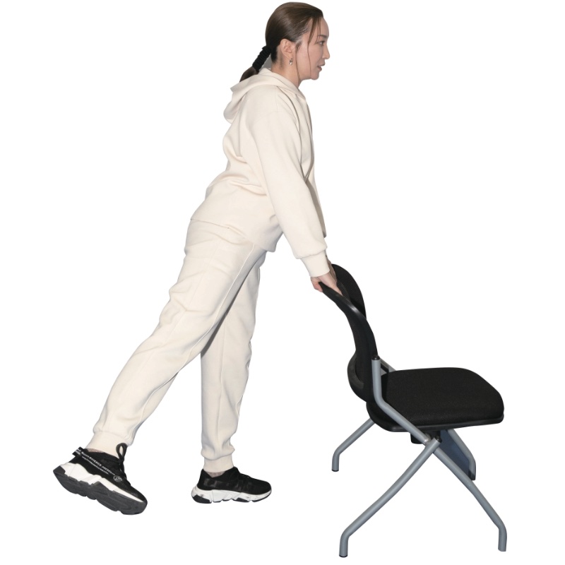 いすの背で体を支え、片足をあげる女性