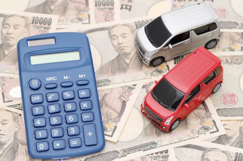 電卓と現金と車の模型